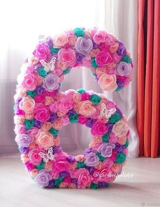 Piñata para cumpleaños de número con decoración cubierta de flores